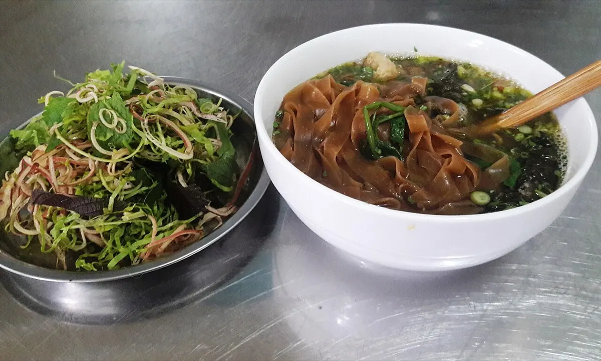 Bát bánh đa cua Hải Phòng sợi đỏ bên đĩa rau sống