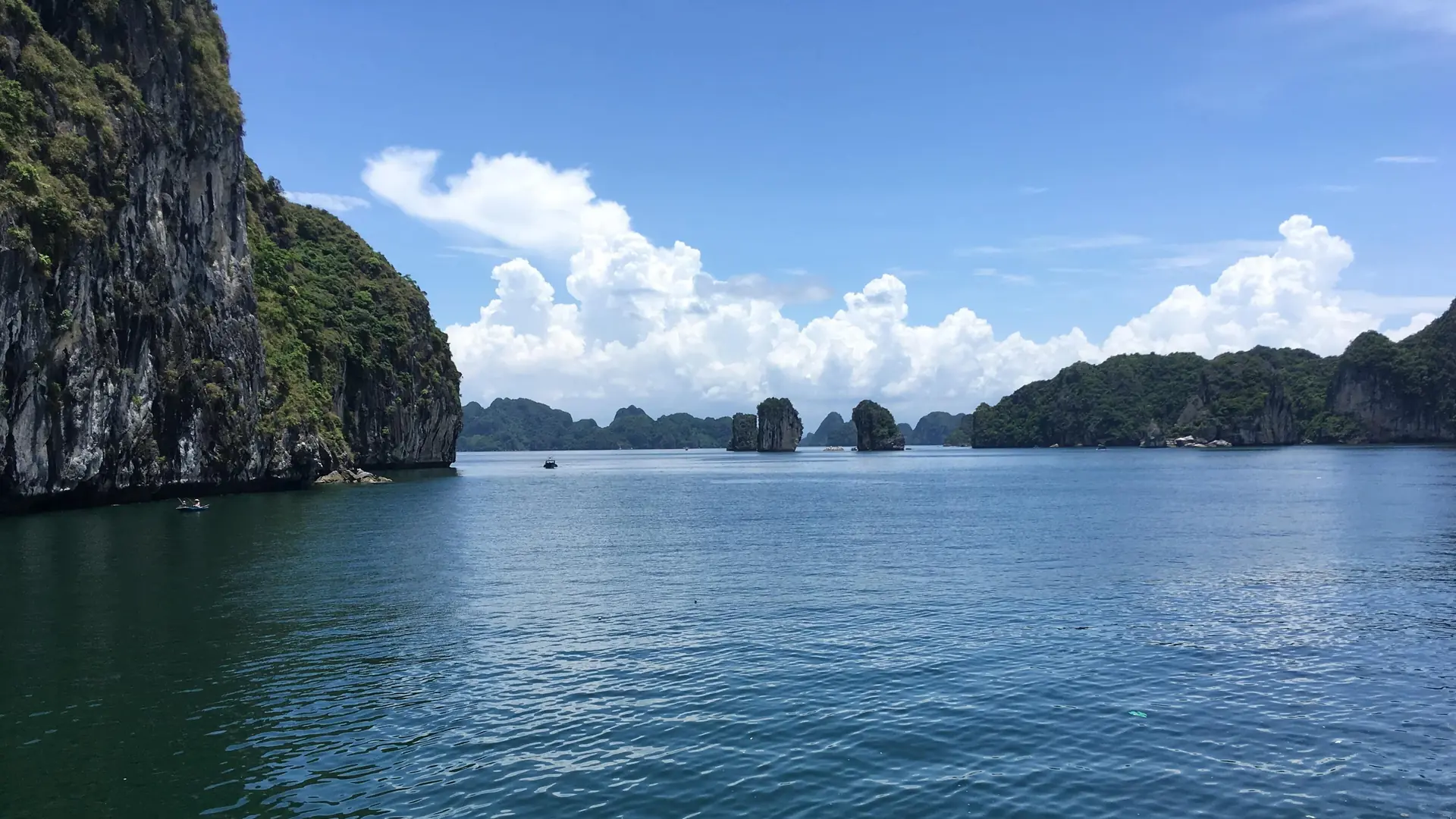 Vịnh Lan Hạ ngày nắng, những đảo đá vôi phủ cây xanh nhô lên giữa mặt nước, phía xa là vịnh Hạ Long