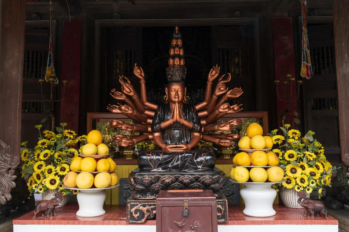 Altar of the thousand-armed Avalokitesvara with pomelos and sunflowers at Du Hang Pagoda, February 2024