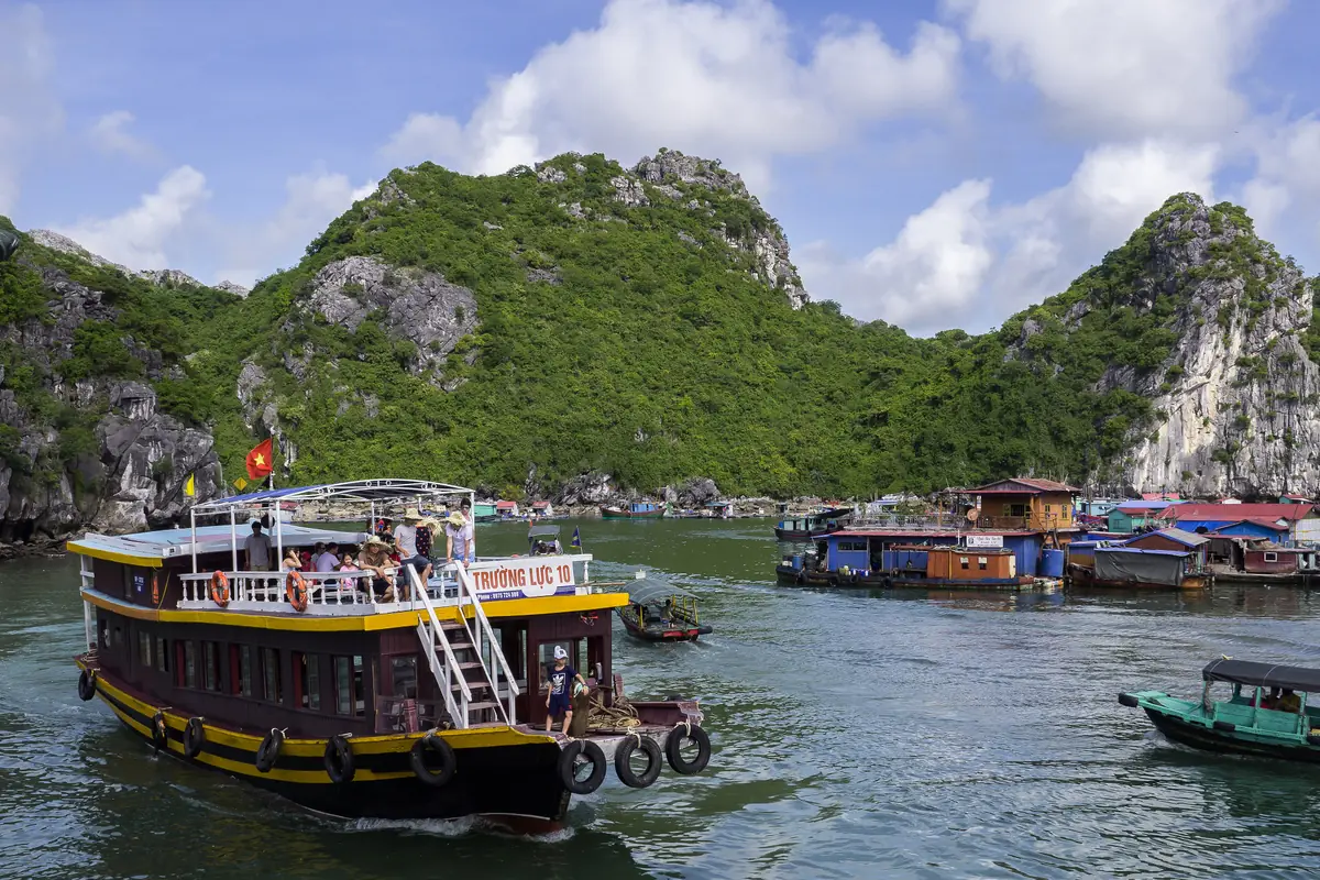 Tàu tham quan hai tầng chạy qua khu nhà bè dưới núi đá ở vịnh Lan Hạ, tháng 6/2017